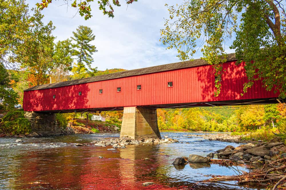 Red wooden covered bridge over a river