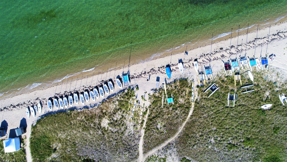 Aerial view of a Nantucket beach lined with lounge chairs next to the ocean