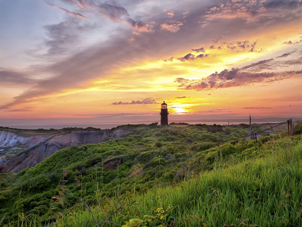 Sunset view of a lighthouse with grass in the foreground