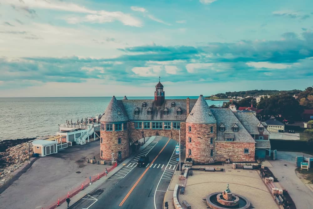 A coquina castle with towers and road going through it right on the beach with the ocean to the left of it