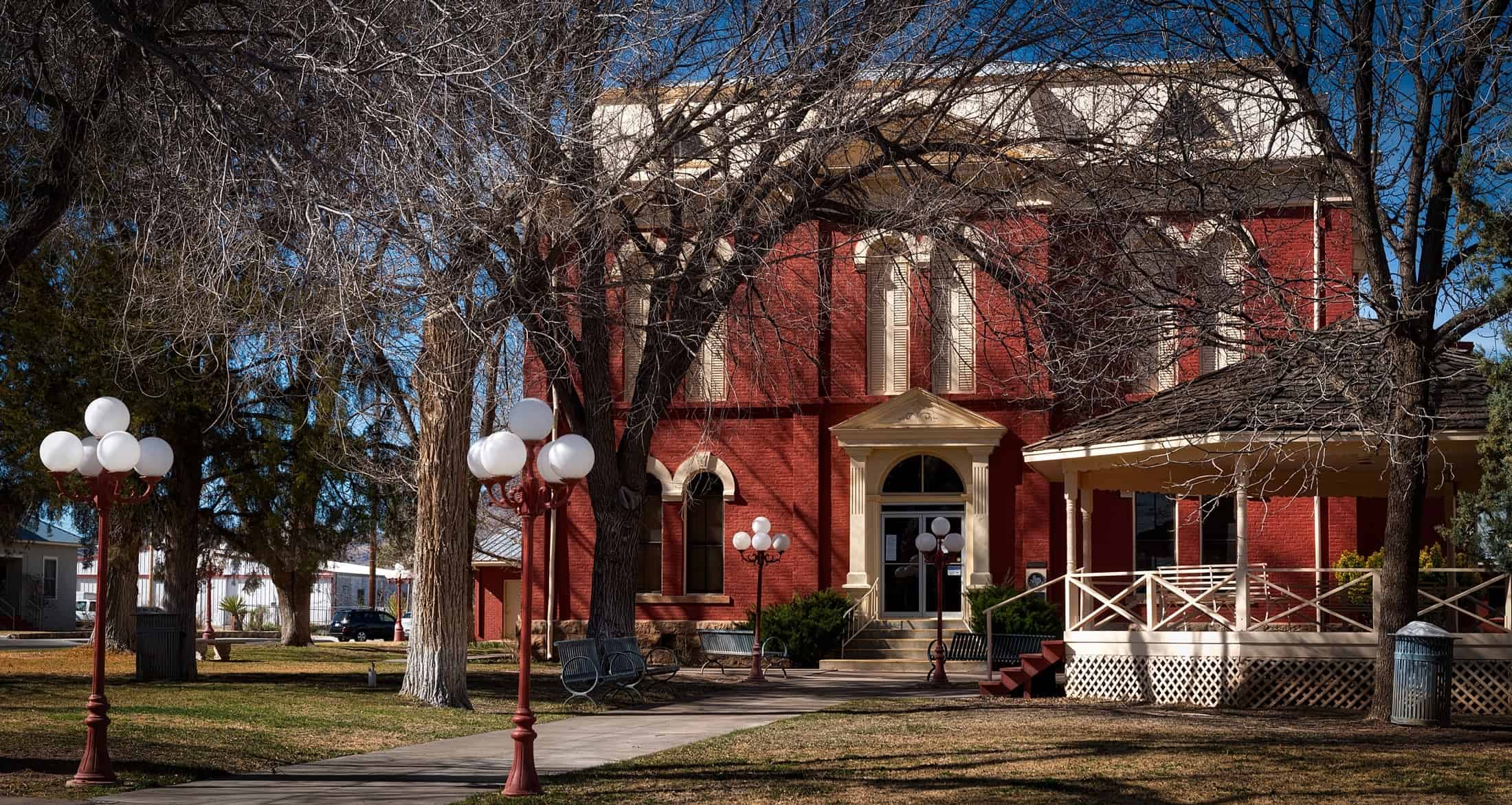 Red brick building with white trim with bare trees in front of it