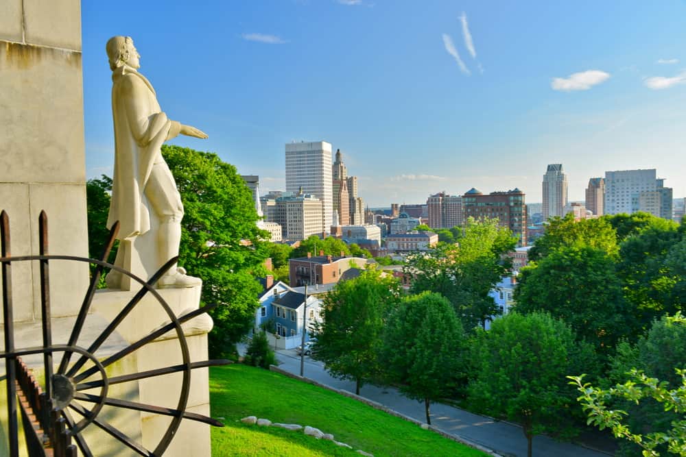 Part of a statue overlooking the park and the city in the background