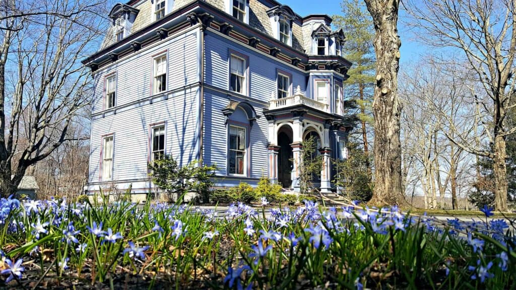 Blue historic building surrounded by flowers