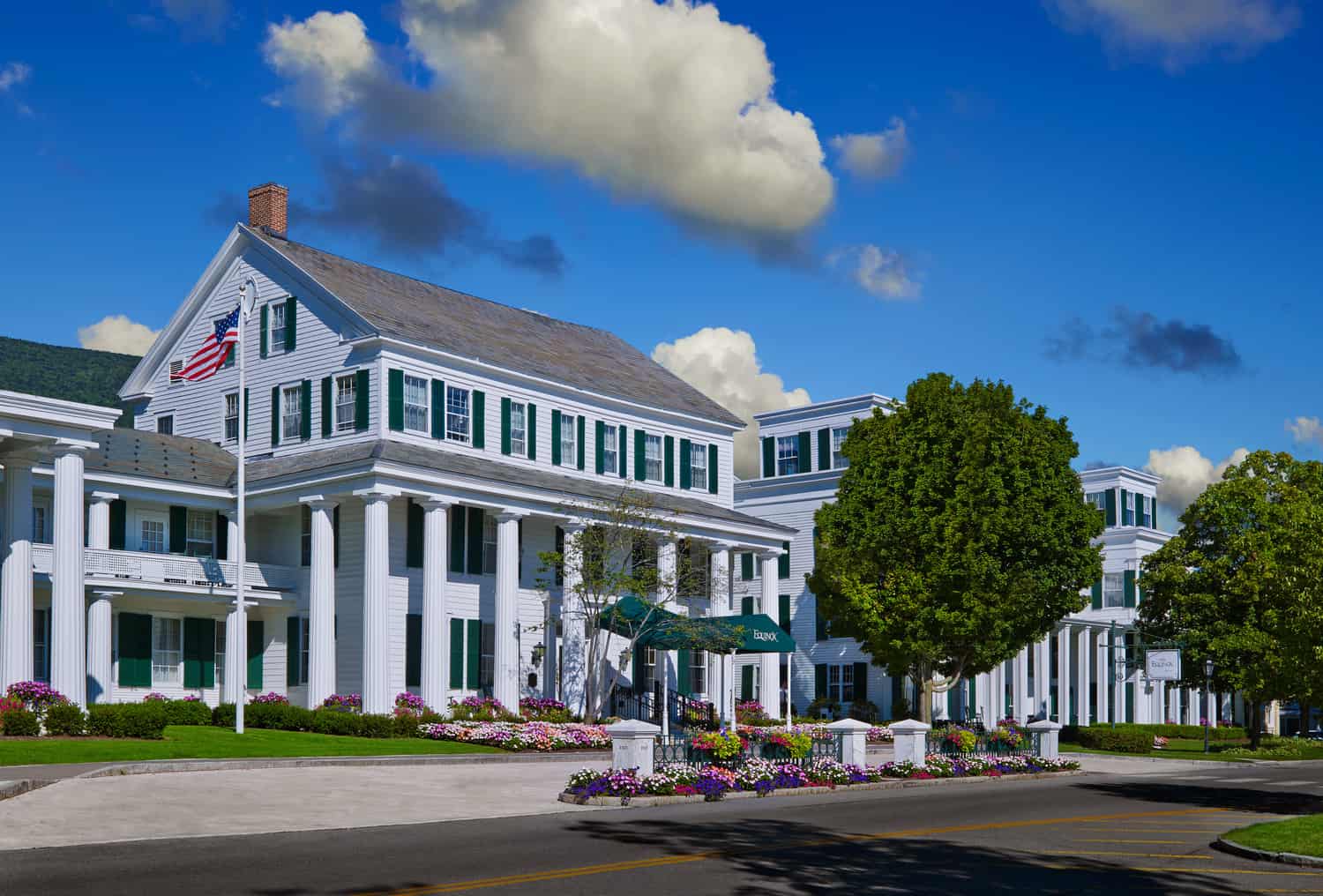 Large white building with many green windows under a blue sky