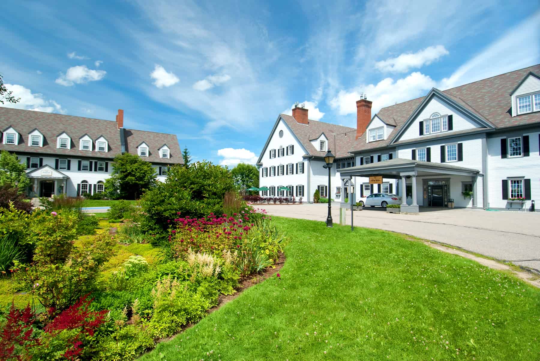 A large brick building with green grass in front of a house