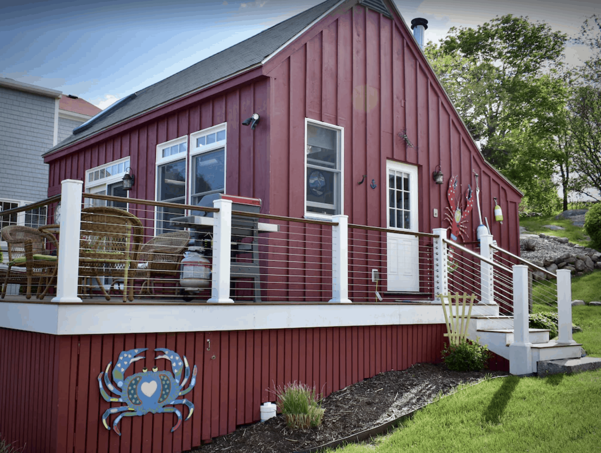 A large red cabin in Massachusetts with a plaque of a blue crab on the exterior. 