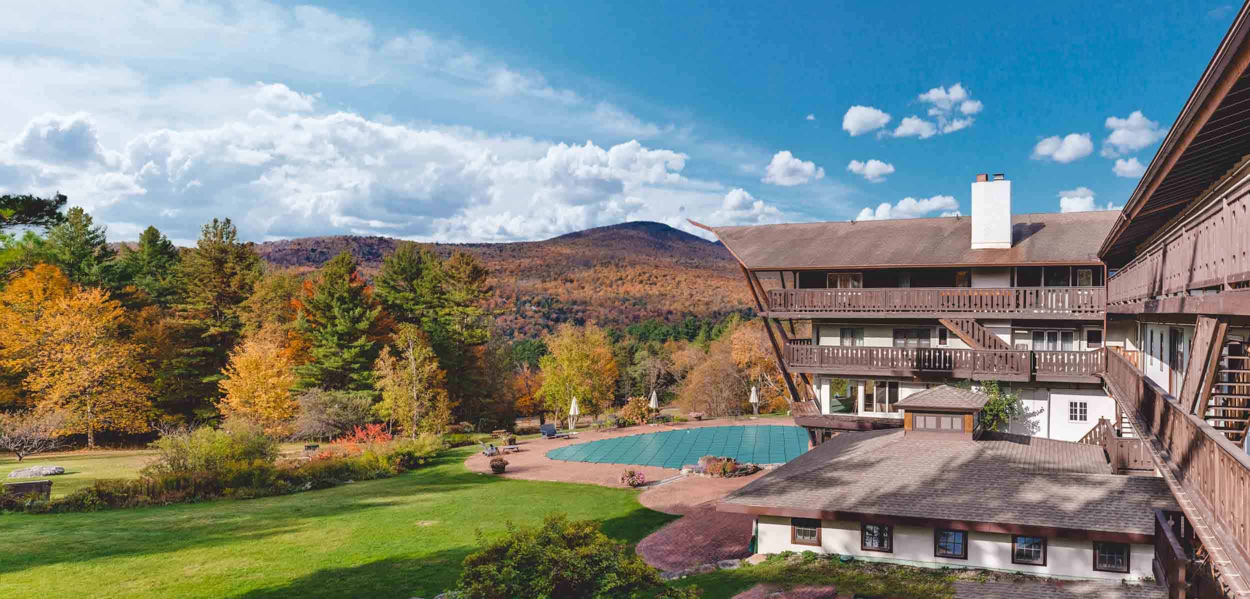 Large modern building with a swimming pool in the mountains on a clear day