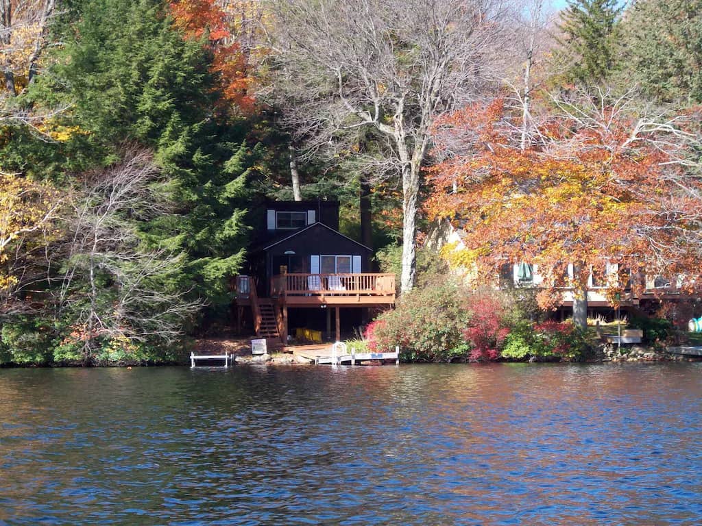 brown cabin right along the lake with a dock
