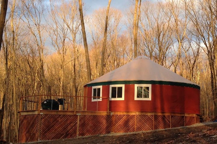 Red yurt surrounded by fall foliage.