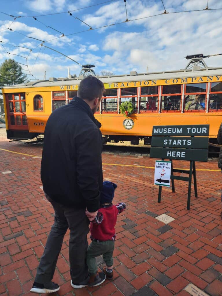 A man holding a toddler's hand at the Seashore Trolley Museum in Kennebunkport