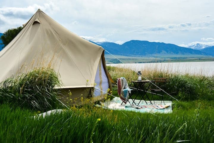 Yurt with a table and chair by the lake and mountains
