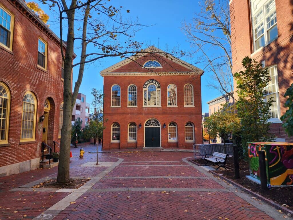 a stately brick building at the end of a wide brick courtyard. The Old Salem Town Hall