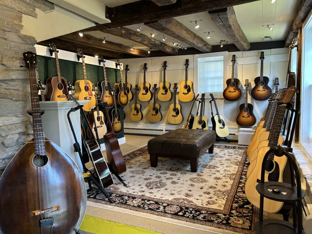 A room full of rare guitars and mandolins with a chair in the center