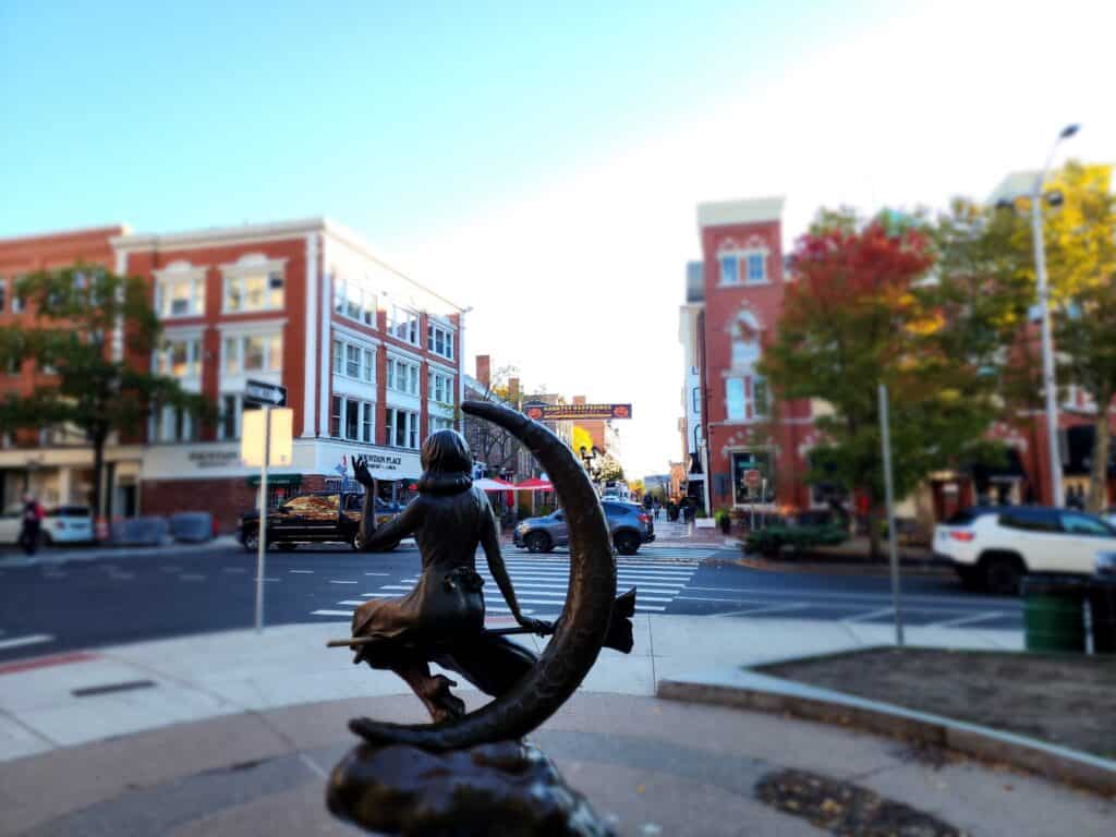 statue of a woman sitting on a crescent moon - the Bewitched Samantha statue in Salem