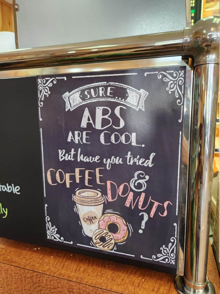 A sign with a cheeky saying about donuts and abs at a cute donut shop in CT