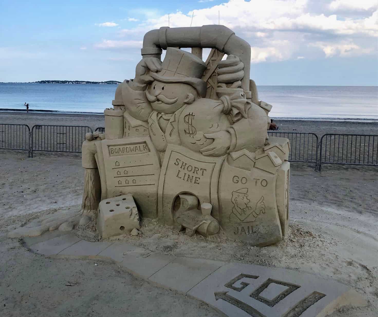 Monopoly-style sand sculpture by the water