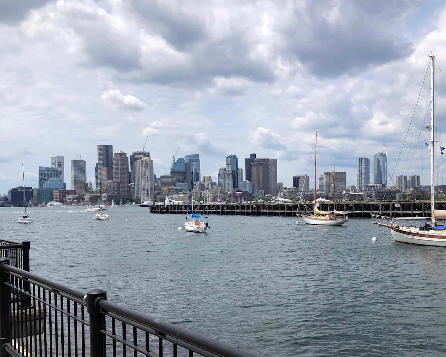 View of the Boston Skyline near the water with boats floating