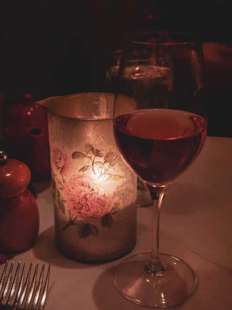 A glass of wine and a candle on a table at a Newport RI restaurant