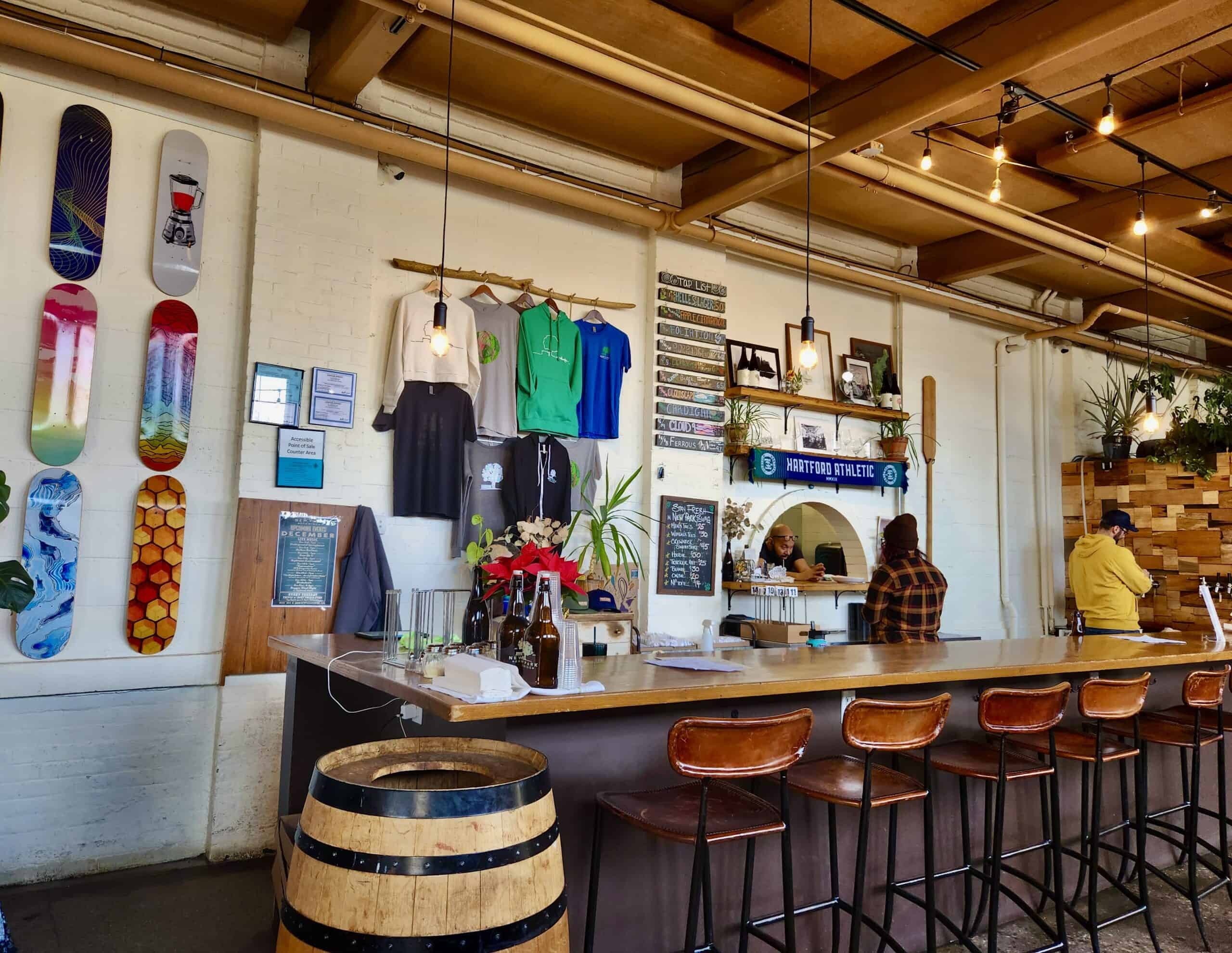 The inside of a Connecticut brewery with skateboards and t shirts hung on the wall