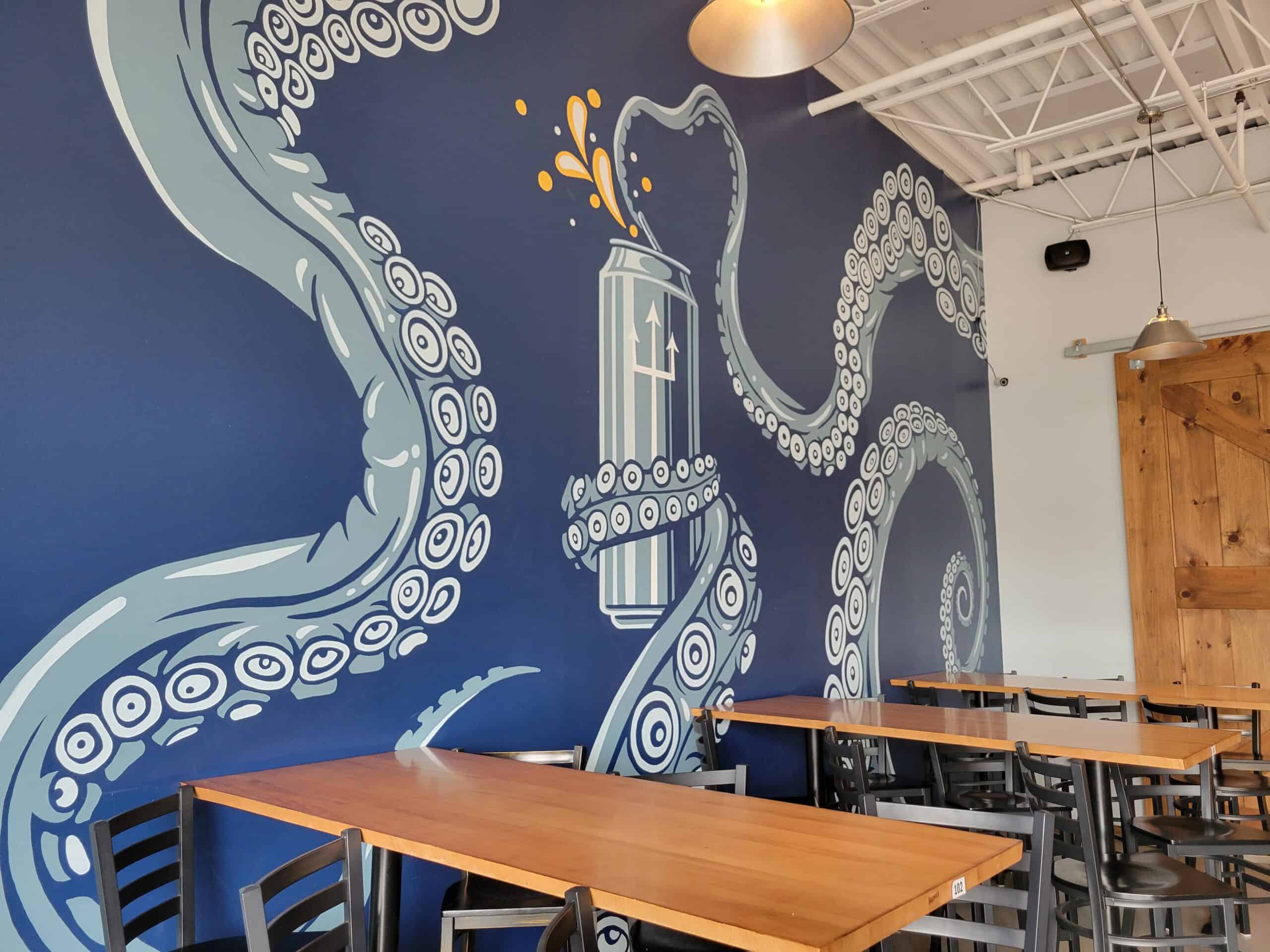 A mural of an octopus' tentacles opening a beer on the wall of one of the most popular Connecticut breweries