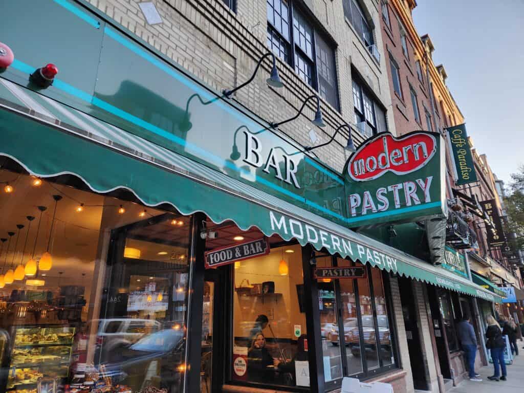The green awning above a storefront for Modern Pastry, one of the top cannoli places in North End Boston