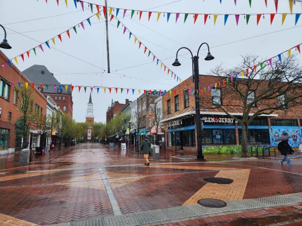 a rainy scene in downtown burlington.wet brick pavement in front of a ben and jerry's ice cream shop