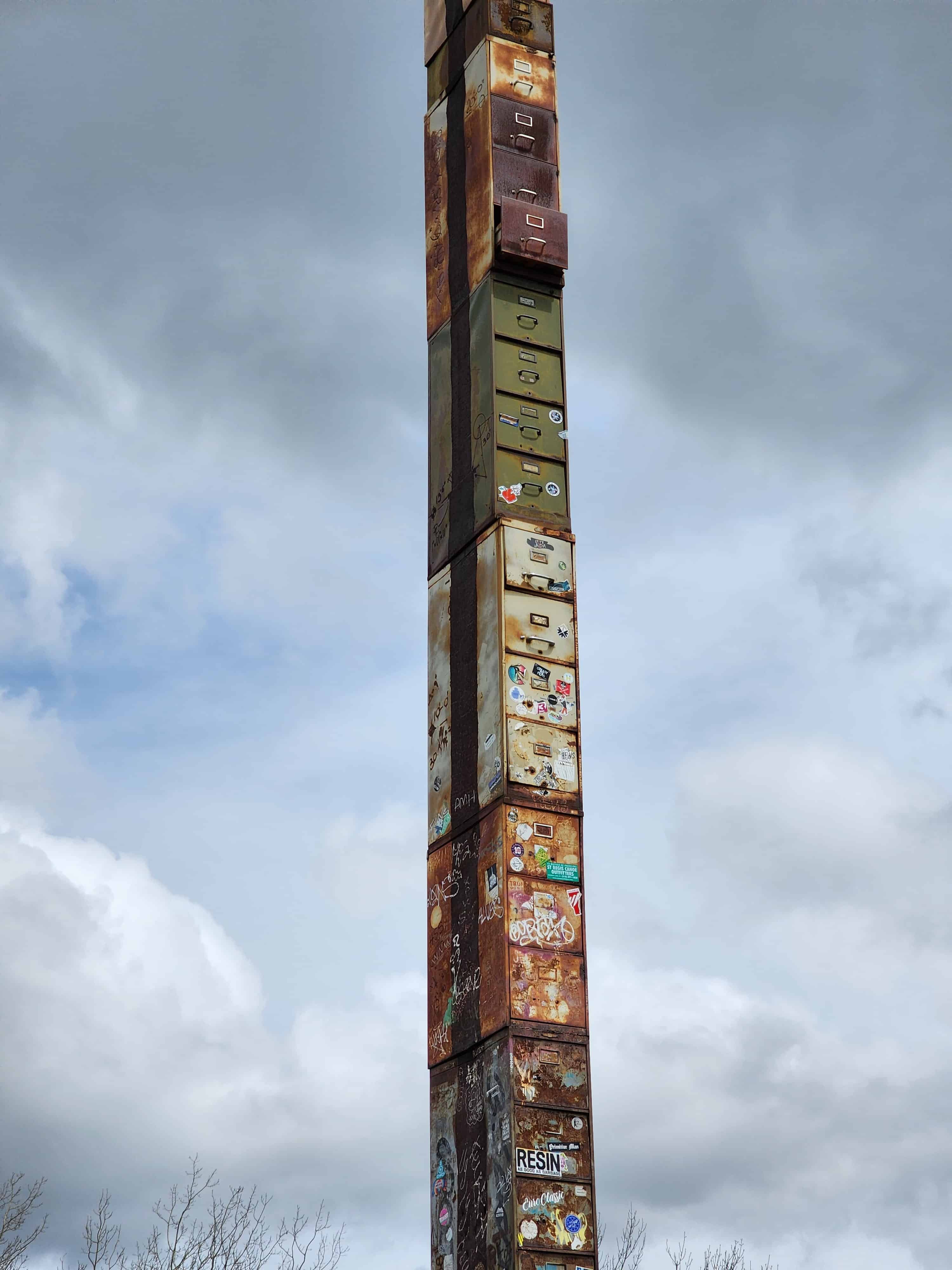 an extremely tall file cabinet rises into a cloudy sky