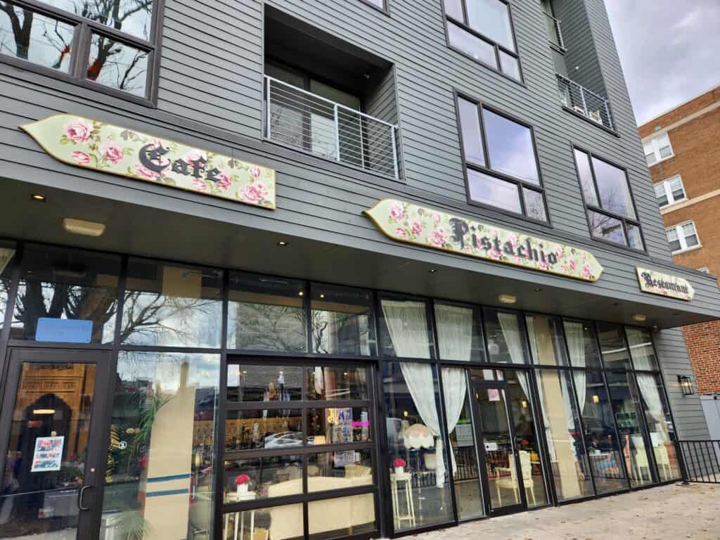 A dark colored building with windows all along the first floor is Pistachio, one of the coolest coffee shops New Haven CT has