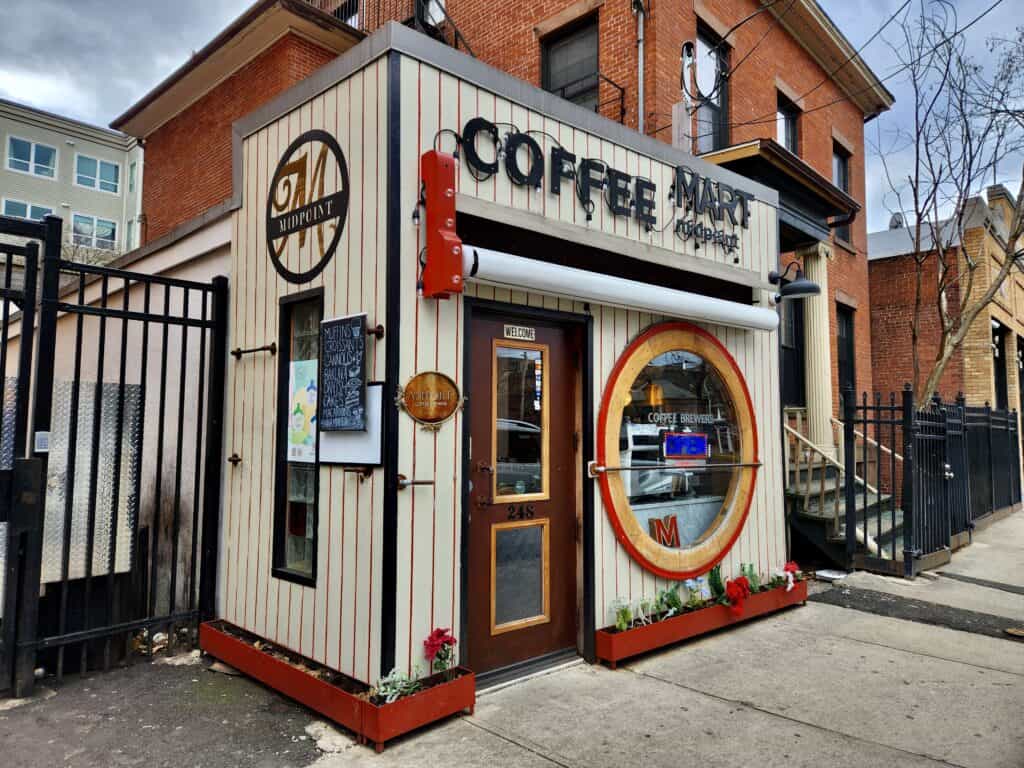 A quaint entrance to a New Haven coffee shop with a wide circular window in front