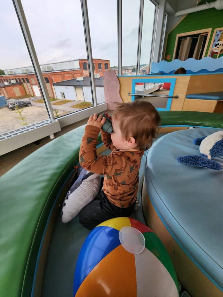 A child plays with kid binoculars at the Children's Museum in Maine of Portland