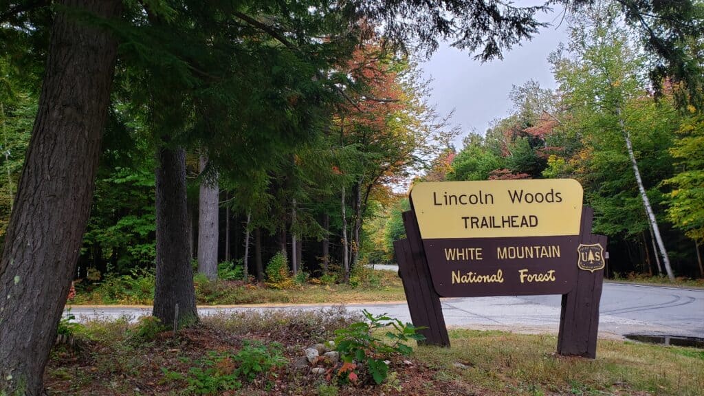 The Lincoln Woods Trailhead White Mountain National Forest Sign with fall foliage around it