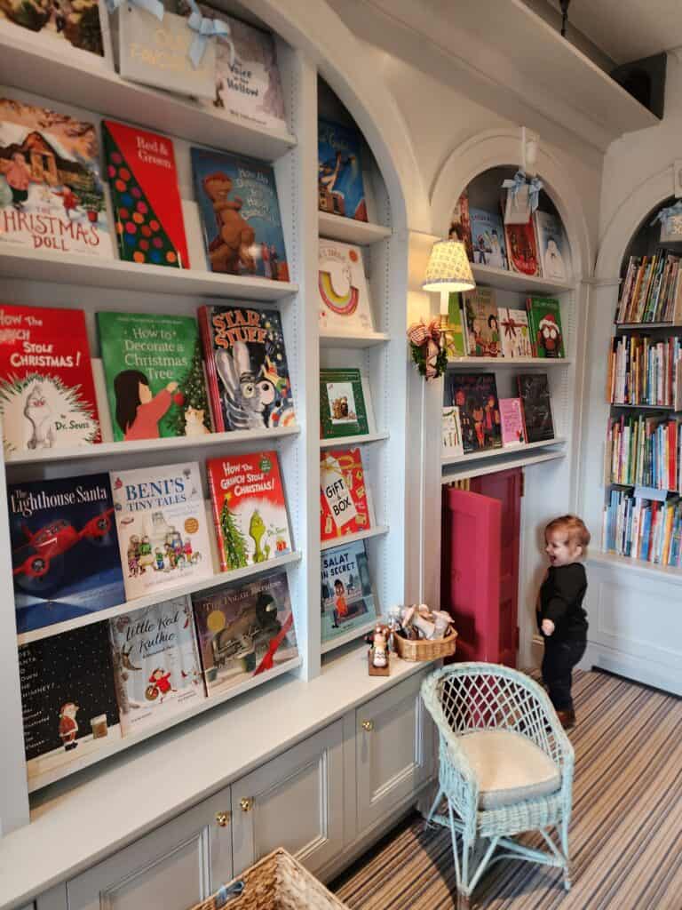 A toddler in the corner of a bookstore in Boston at Christmas time