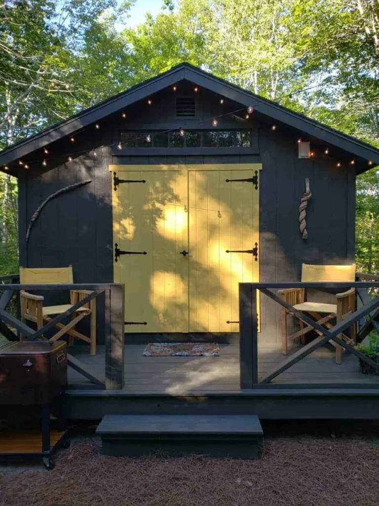 A quaint glamping cabin with yellow doors and a cozy porch