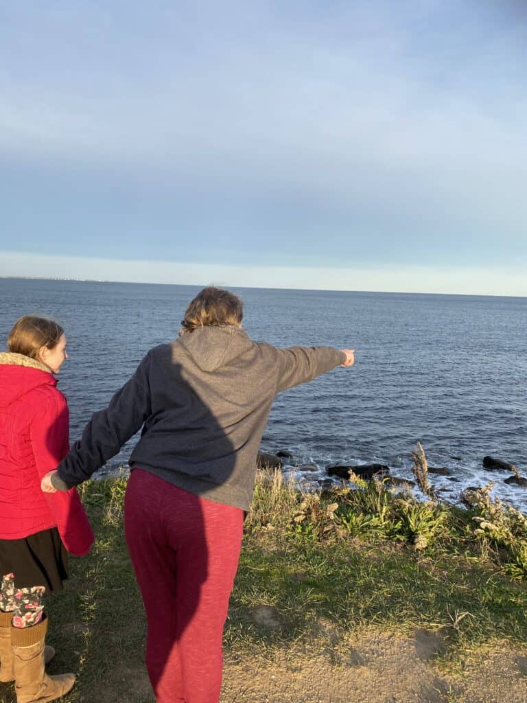 Kids pointing and looking out at the ocean near Point Judith Lighthouse in Narragansett, Rhode Island