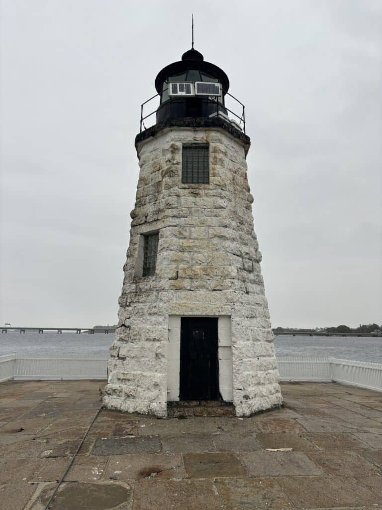 A white lighthouse in Rhode Island sits perched on Goat Island near Newport, Rhode Island