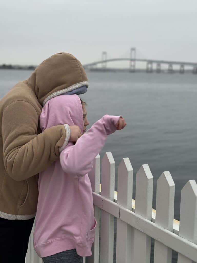 Two kids look out towards the Claiborne Pell bridge in Newport, Rhode Island