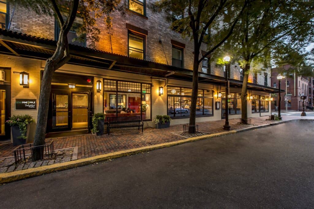 The exterior of one of the best boutique hotels Boston has is seen at night with exterior lights and interior lights glowing from within