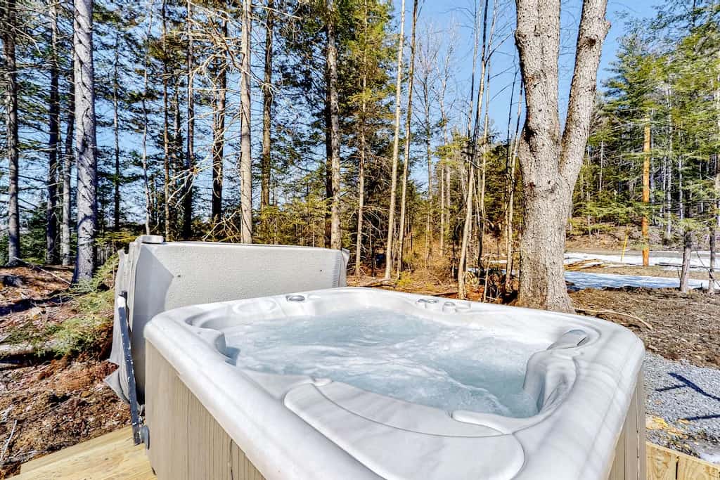 Hot tub outdoors with the woods nearby.