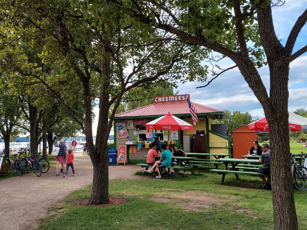 a summery photo of people enjoying ice cream in front of a creemee stand