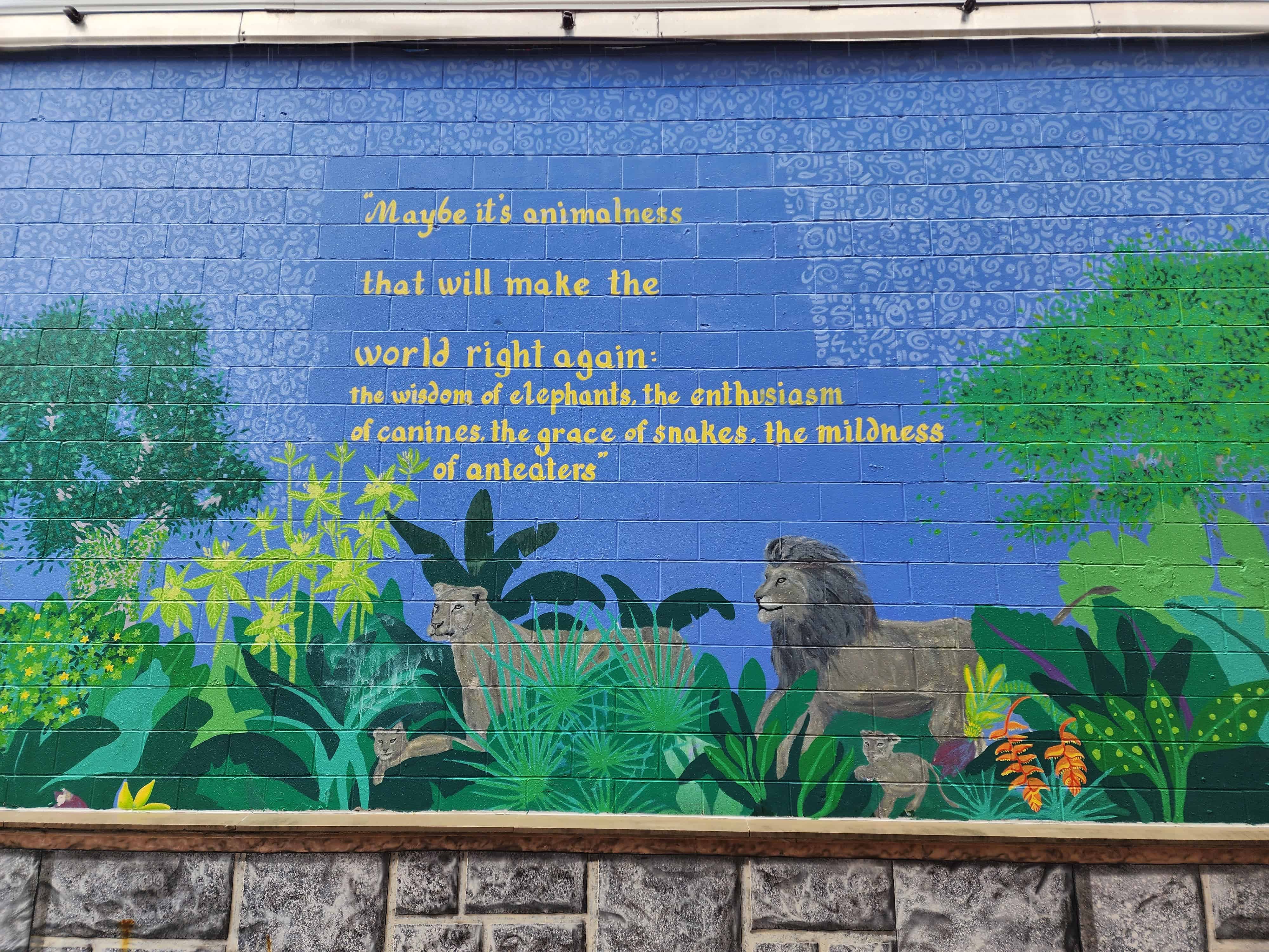 mural of jungle animals, leaves, and a quote