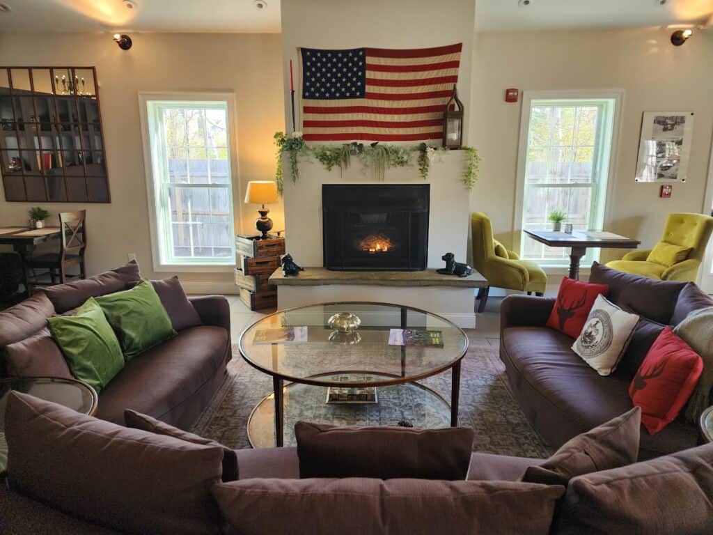 A cozy room at a Vermont inn with fireplace blazing and an American flag above