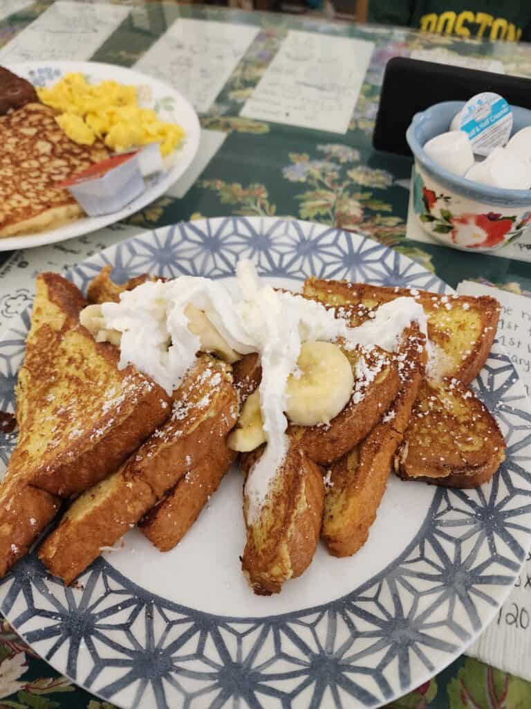 a delicious breakfast spread on a table: french toast plus eggs, pancakes, and sausage
