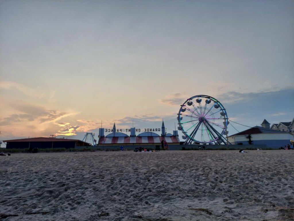 A sandy beach with a ferris wheel in the background at Old Orchard Beach, Maine