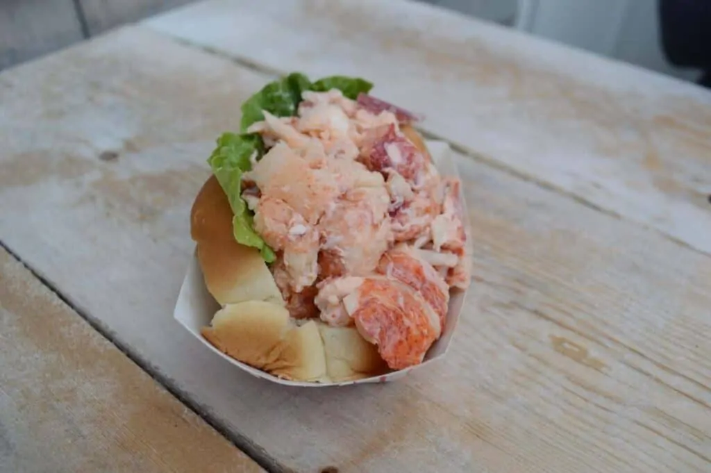A close up of an overstuffed seafood roll that is a contender for best lobster roll in Massachusetts.