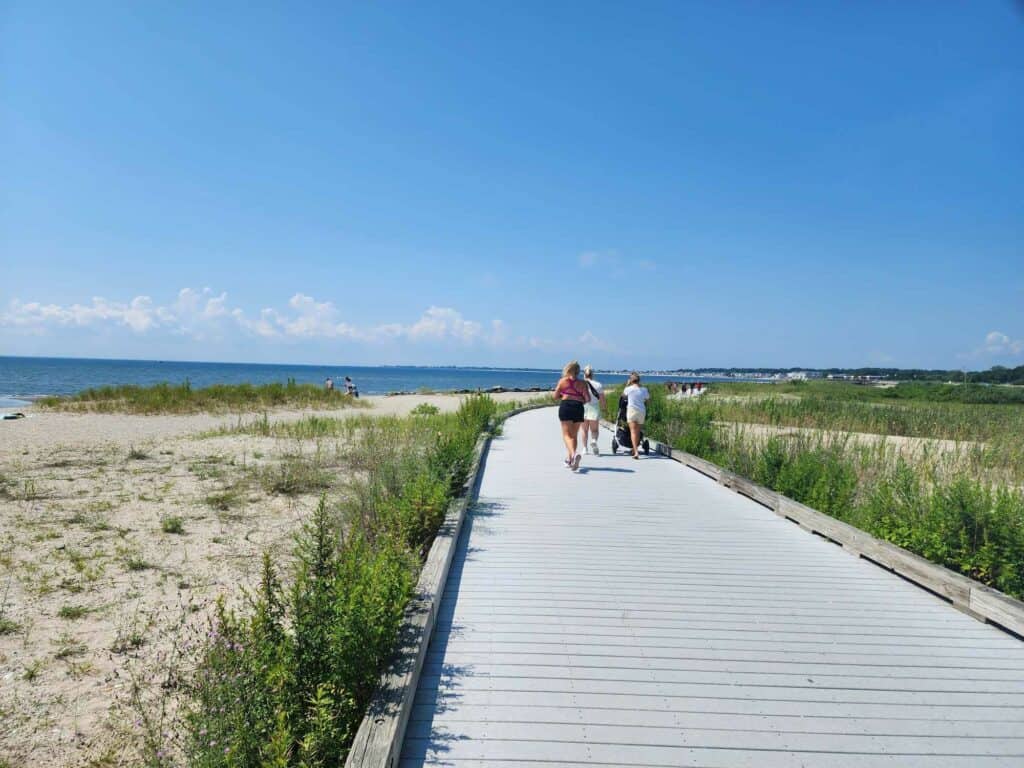 A boardwalk on sand at a beach in Milford, Connecticut