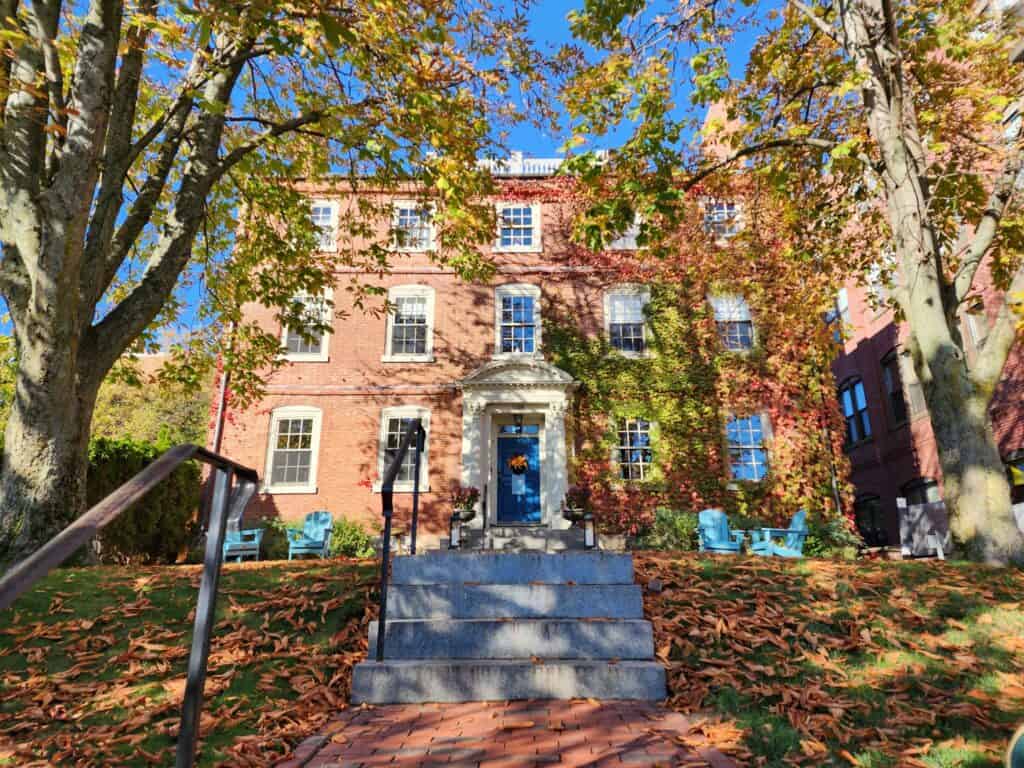 The brick historic Joshua Ward House is seen surrounded by fall foliage