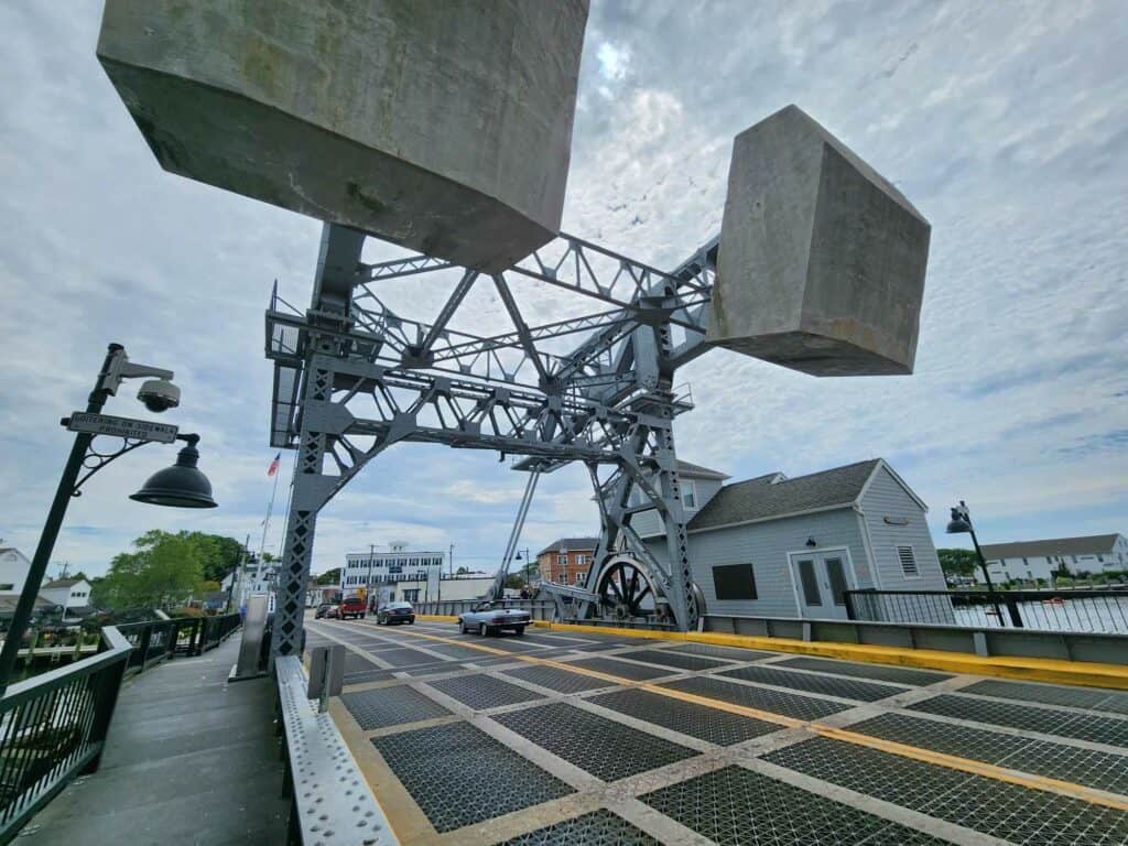 view of a drawbridge that is down with two massive granite blocks hovering overhead: these are the mechanism for raising the bridge