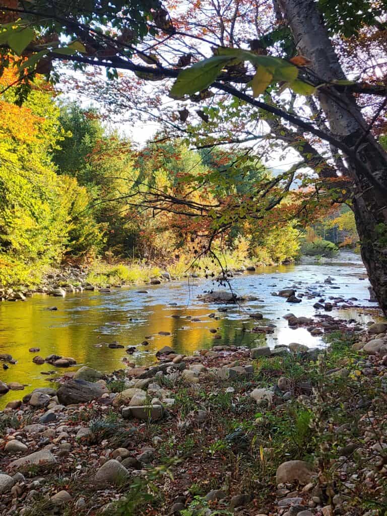 Early autumn colors surround a river in New Hampshire in fall