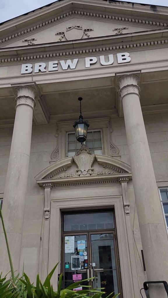 an old bank has been turned into a pub, image shows tall columns and sign reading brew pub