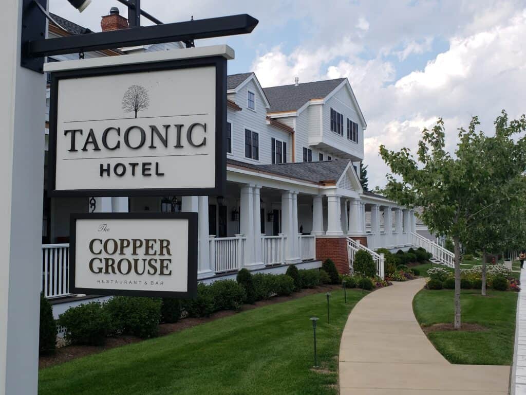 exterior of the taconic hotel in manchester vt with sign
